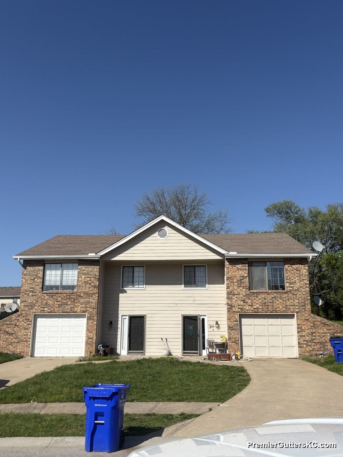 1990s brick and cream split-level home with replacement seamless gutters in Kansas City