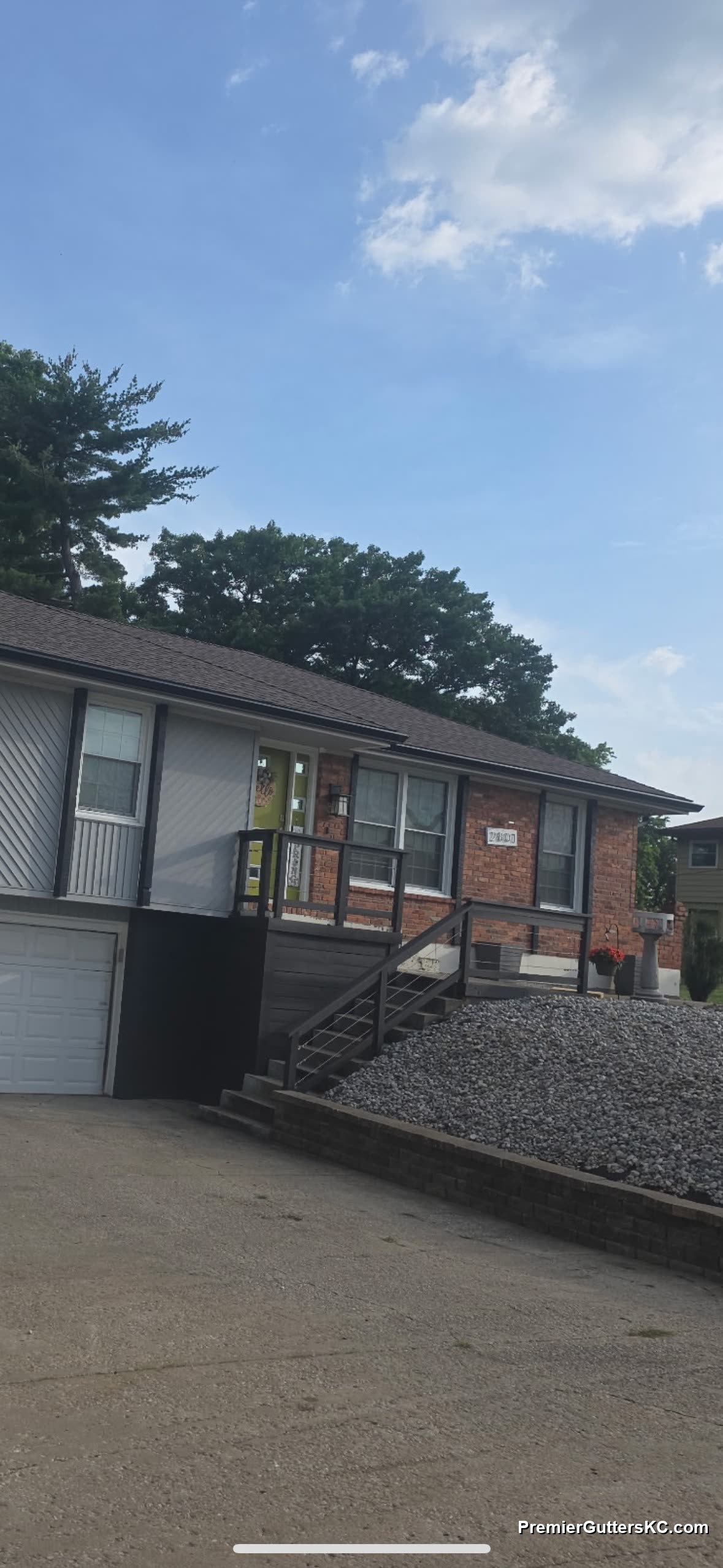 1990s brick split-level Kansas City home with new black seamless gutters installed