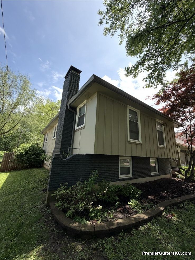 1990s split-foyer home with green siding and new seamless gutters in Kansas City