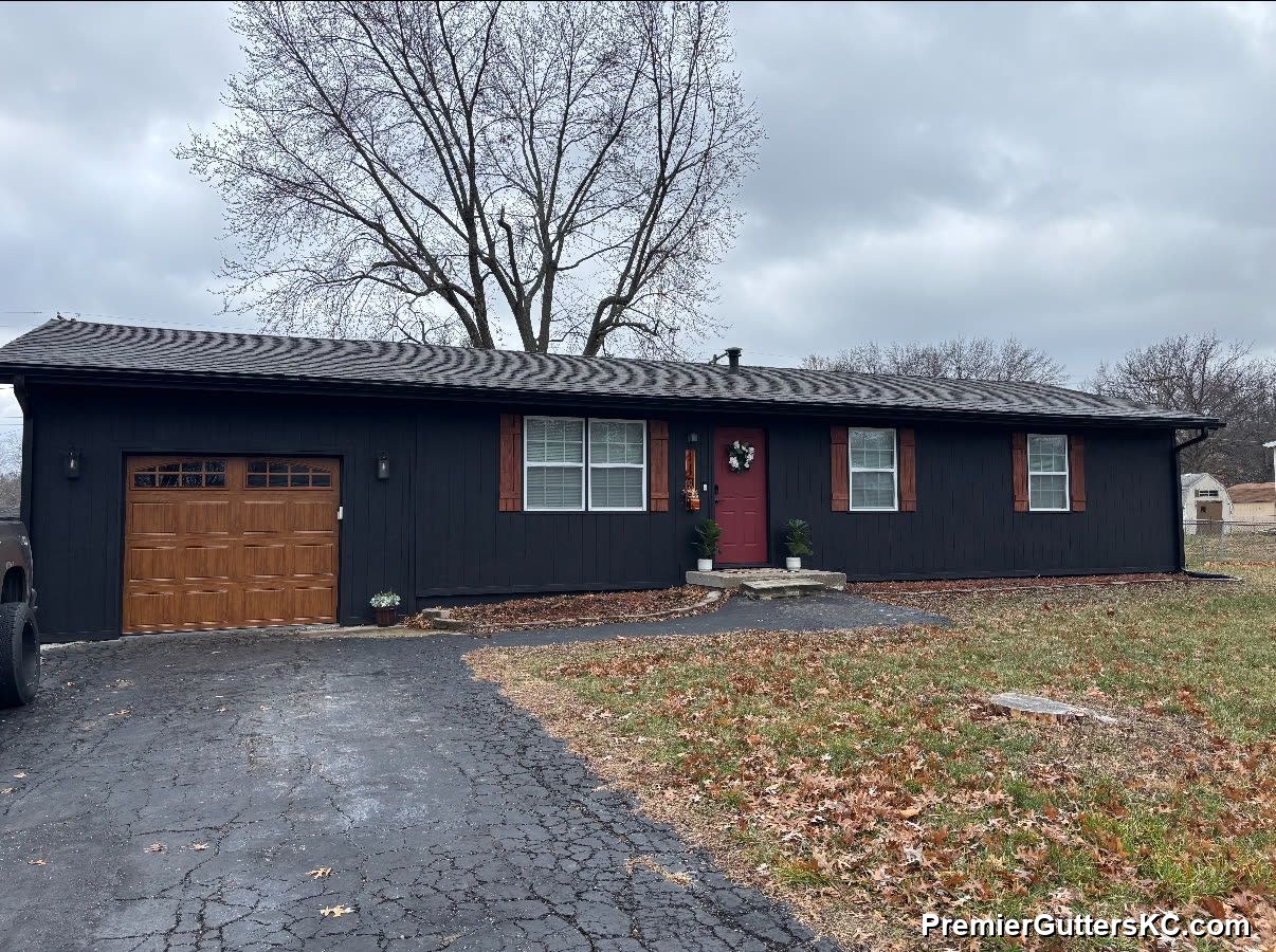 Black seamless gutters on board-and-batten ranch with tan garage in Kansas City