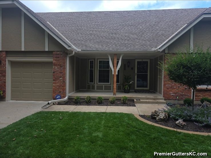 Long single-story ranch home with blue-gray siding and an attached garage, finished with white seamless gutters in the Kansas City metro