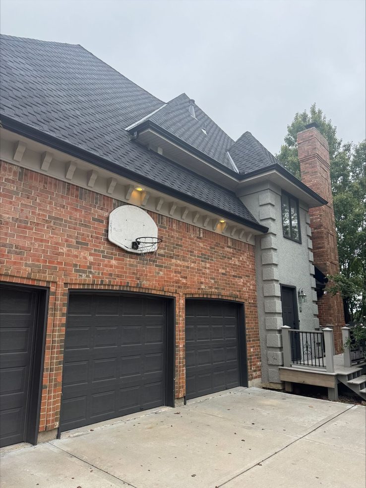 New black seamless gutters on a brick two-story home in Overland Park, KS - Premier Gutters KC works across the Kansas side of the metro