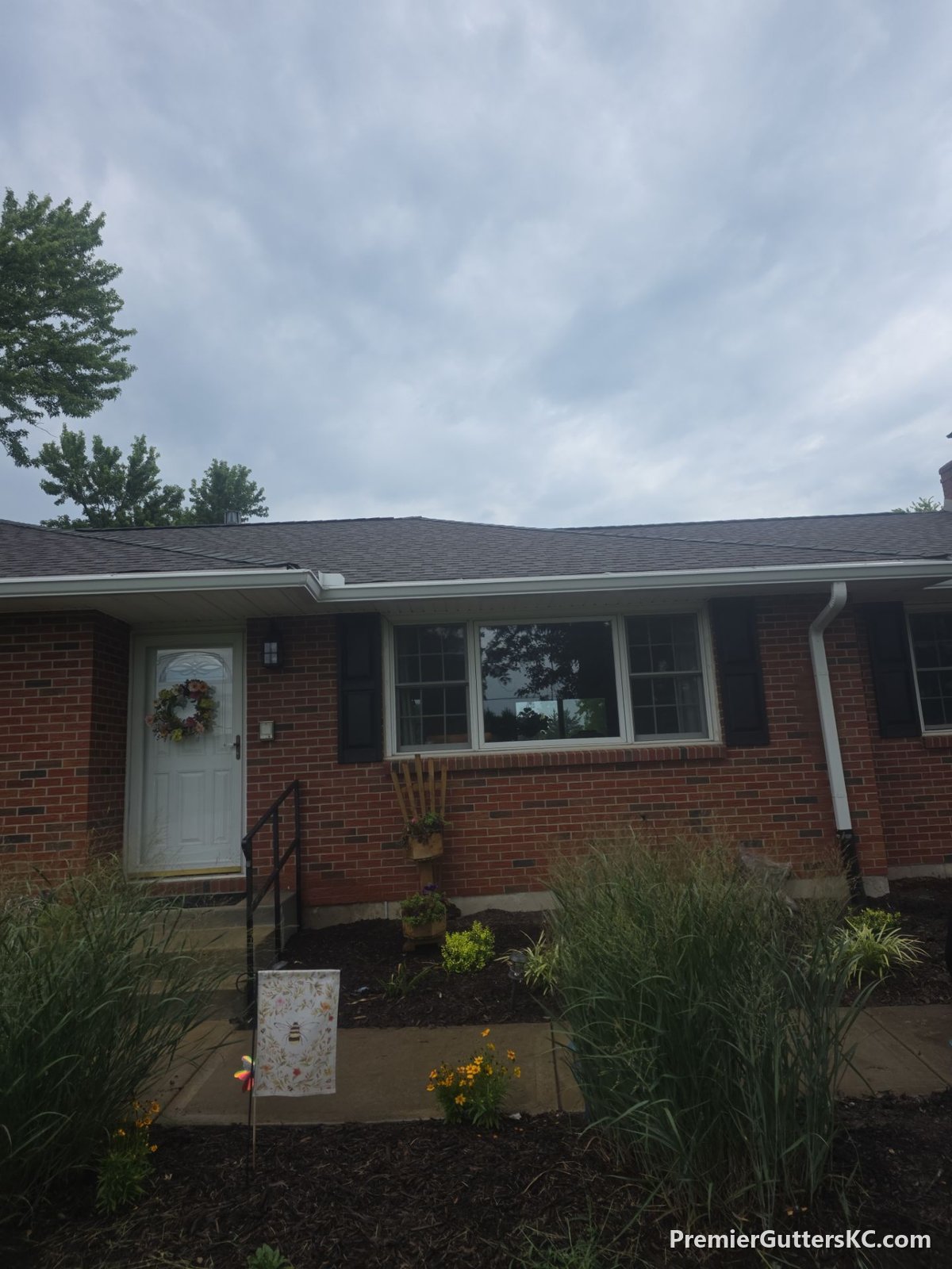 New white seamless gutters on a red brick ranch home in De Soto, Kansas